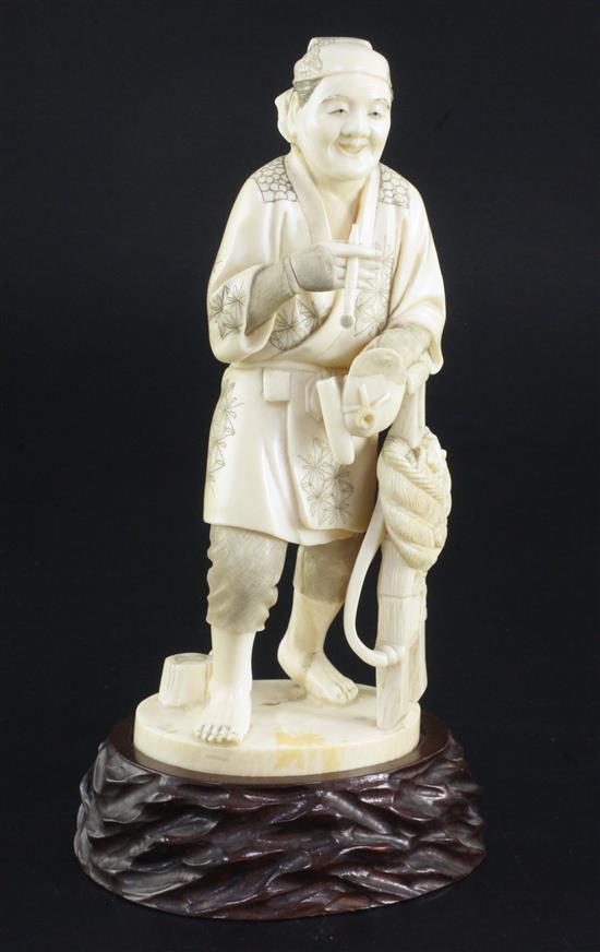 A Japanese ivory figure of a farmer holding his pipe, signed Gyozan, early 20th century, 17.5cm excl. wood stand